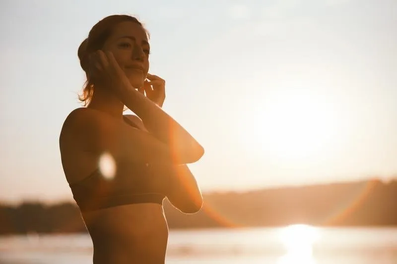 Mulher contra a luz no pôr-do-sol.