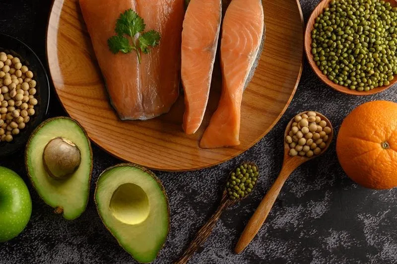 Foto de um abacate, salmão, tangerina e leguminosas