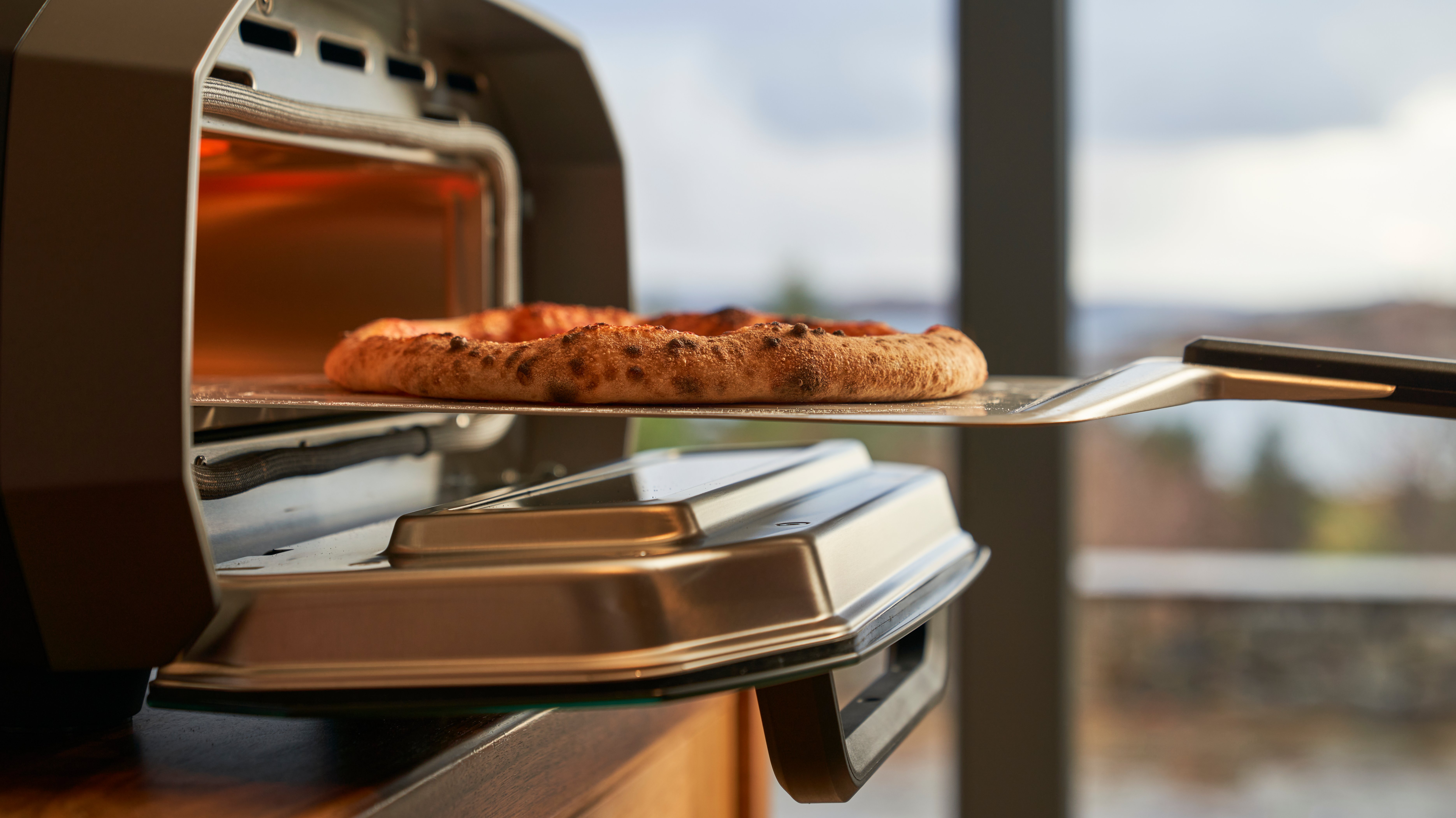 ooni-volt-12-indoor-retrieving-pizza